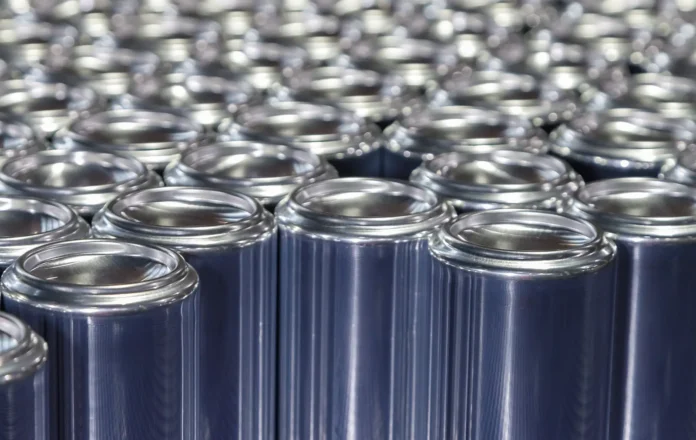 Imagem de várias latas de alumínio de bebidas sendo produzidas. Elas correm por uma esteira metálica e ilustram o tema principal do Congresso Internacional de Embalagens Metálicas (OneCan)